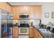 This kitchen features modern stainless steel appliances, wood cabinets, and granite countertops at 2898 Oakwater Dr # 2898, Kissimmee, FL 34747