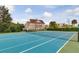 A well-maintained tennis court, with blue surface, is set against the backdrop of community townhomes at 2898 Oakwater Dr # 2898, Kissimmee, FL 34747