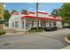 Exterior view of a commercial building with a red and white awning, palm trees, and street parking at 33332 Seattle Slew Dr, Sorrento, FL 32776
