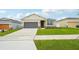 Charming single-story home with a two-car garage, complemented by lush green lawn and landscaping at 33332 Seattle Slew Dr, Sorrento, FL 32776