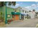 A row of colorful storefronts on a brick street, with unique designs and outdoor seating at 33332 Seattle Slew Dr, Sorrento, FL 32776