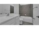 Bathroom with gray tiled shower and flooring, and white cabinets and countertop at 33343 Seattle Slew Dr, Sorrento, FL 32776