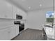 Bright kitchen boasts white cabinets, quartz countertops, stainless steel appliances, and stylish gray flooring at 33343 Seattle Slew Dr, Sorrento, FL 32776