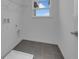 Functional laundry room features tile flooring, a window for natural light, and hookups for appliances at 33343 Seattle Slew Dr, Sorrento, FL 32776