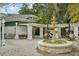 Picturesque courtyard with a stone fountain, lush plants, and outdoor seating; a perfect spot to relax at 33436 Seattle Slew Dr, Sorrento, FL 32776