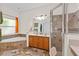 Bathroom includes double vanity, large mirror, walk-in shower, soaking tub with mosaic backsplash and travertine floors at 3344 Quailwest Ct, Orlando, FL 32812