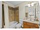 This bathroom features a shower and tub combination, along with a charming vanity and ample lighting at 3344 Quailwest Ct, Orlando, FL 32812