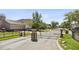 Community entrance gate with stone columns and wrought iron for privacy and security at 3344 Quailwest Ct, Orlando, FL 32812