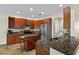 A kitchen boasts wooden cabinets, stainless steel appliances, and granite countertops with an island at 3344 Quailwest Ct, Orlando, FL 32812