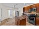 Kitchen featuring wood cabinets, stainless steel appliances, granite countertops, kitchen island, and a window for natural light at 3344 Quailwest Ct, Orlando, FL 32812