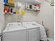 Functional laundry room with a washer, dryer, and shelving for organization at 3344 Quailwest Ct, Orlando, FL 32812