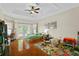 Spacious main bedroom with hardwood floors, tray ceilings, a ceiling fan, and direct access to the backyard at 3344 Quailwest Ct, Orlando, FL 32812
