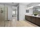 Modern bathroom with double vanity, tiled floors, a walk-in shower, and neutral color palette at 3375 Hanging Tide St, Winter Garden, FL 34787