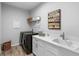 Well-lit laundry room with modern appliances, cabinetry, sink, and stylish decor at 3375 Hanging Tide St, Winter Garden, FL 34787