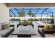 Screened outdoor seating area with wicker furniture around a firepit overlooking the pool at 3375 Hanging Tide St, Winter Garden, FL 34787