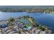 Aerial view of lakeside condos with pool and fountain surrounded by trees and a beautiful lake at 3384 Corona Village Way # 202, Orlando, FL 32835