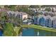 Aerial view of colorful buildings, a pool, a pond with fountain, and trees in this lakeside community at 3384 Corona Village Way # 202, Orlando, FL 32835