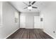 This bedroom features a ceiling fan, two windows, and dark wood laminate flooring at 3384 Corona Village Way # 202, Orlando, FL 32835
