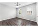 This bedroom features a ceiling fan, two windows, and dark wood laminate flooring at 3384 Corona Village Way # 202, Orlando, FL 32835