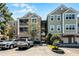Exterior view of a three-story condo building with manicured landscaping and parking at 3384 Corona Village Way # 202, Orlando, FL 32835