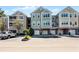 Three-story condominium building with individual garages and well-maintained landscaping at 3384 Corona Village Way # 202, Orlando, FL 32835