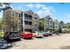 Condominium building featuring multiple units, balconies, and ample parking spaces for residents at 3384 Corona Village Way # 202, Orlando, FL 32835