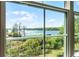 Scenic view of the lake through a large window, showcasing lush greenery and tranquil water at 3384 Corona Village Way # 202, Orlando, FL 32835