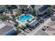 Aerial view of community pool with lounge chairs, well-maintained landscaping, and nearby buildings and parking area at 3384 Corona Village Way # 202, Orlando, FL 32835