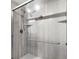 Updated shower features glass doors, a rainfall shower head, and gray tile at 3384 Corona Village Way # 202, Orlando, FL 32835