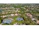 Aerial view showcasing the home's location within a golf course community with tennis courts at 3400 Park Grove Ct, Longwood, FL 32779