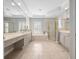 A full bathroom with dual vanity sinks, a soaking tub, and a separate shower with glass doors at 3400 Park Grove Ct, Longwood, FL 32779