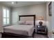 Bedroom featuring a comfortable bed, nightstand with lamp, and a window with plantation shutters at 3400 Park Grove Ct, Longwood, FL 32779