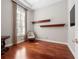 Bright bedroom featuring hardwood floors, plantation shutters, and wooden shelving at 3400 Park Grove Ct, Longwood, FL 32779
