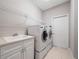 A laundry room features a washer, dryer, white cabinets and tile flooring at 3400 Park Grove Ct, Longwood, FL 32779