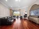 Bright living room featuring hardwood floors, a large sofa, and sliding glass doors leading to an outdoor patio at 3400 Park Grove Ct, Longwood, FL 32779