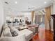 Bright living room with hardwood floors, a comfortable sofa, and open floor plan leading to the kitchen and outdoor patio at 3400 Park Grove Ct, Longwood, FL 32779