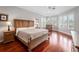 Bright primary bedroom featuring hardwood floors, a king bed and windows with plantation shutters at 3400 Park Grove Ct, Longwood, FL 32779