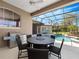 Covered patio featuring an outdoor kitchen, a table with seating, and a view of the screened-in pool at 3400 Park Grove Ct, Longwood, FL 32779
