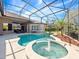 Covered, screened-in pool with a spa, a tropical tree, and tile accents set into a concrete surround at 3400 Park Grove Ct, Longwood, FL 32779