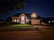 Charming brick home featuring a well-manicured lawn and attached two-car garage, illuminated at night at 437 Wilmington Cir, Oviedo, FL 32765