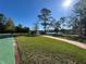 Community park with paved walkway leading to a covered gazebo and lake view, surrounded by lush greenery at 437 Wilmington Cir, Oviedo, FL 32765