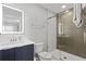 Modern bathroom featuring a sleek vanity, illuminated mirror, and a glass-enclosed shower at 4445 Le Reve Ct, Kissimmee, FL 34746
