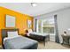 Comfortable bedroom featuring twin beds, a bright accent wall, and ample natural light from the large window at 4445 Le Reve Ct, Kissimmee, FL 34746