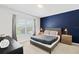 Serene bedroom features a calming color palette, a large window, and stylish bedside tables with lamps at 4445 Le Reve Ct, Kissimmee, FL 34746