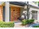 Modern home exterior showing wood siding and covered porch with bench and manicured shrubs at 4445 Le Reve Ct, Kissimmee, FL 34746