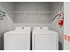 Functional laundry room with side by side washer and dryer units, and overhead shelving at 4445 Le Reve Ct, Kissimmee, FL 34746