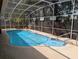 Inviting screened-in pool surrounded by a concrete patio and lush landscaping at 4798 Windwood Dr, Kissimmee, FL 34746