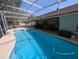 Large screened-in pool with concrete patio and seating area, perfect for outdoor enjoyment at 4798 Windwood Dr, Kissimmee, FL 34746