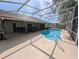 A screened-in pool with concrete patio and outdoor furniture, perfect for relaxation and entertainment at 4798 Windwood Dr, Kissimmee, FL 34746