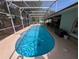 Spacious screened-in pool with concrete patio and seating, offering a private backyard retreat at 4798 Windwood Dr, Kissimmee, FL 34746
